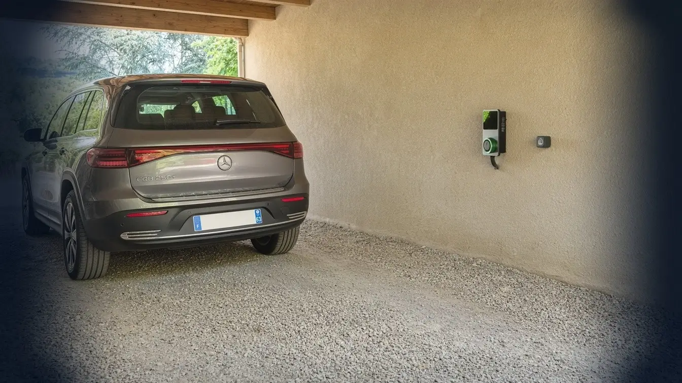 Voiture électrique Mercedes EQB stationnée sous un auvent, borne de recharge Autel fixée au mur à côté